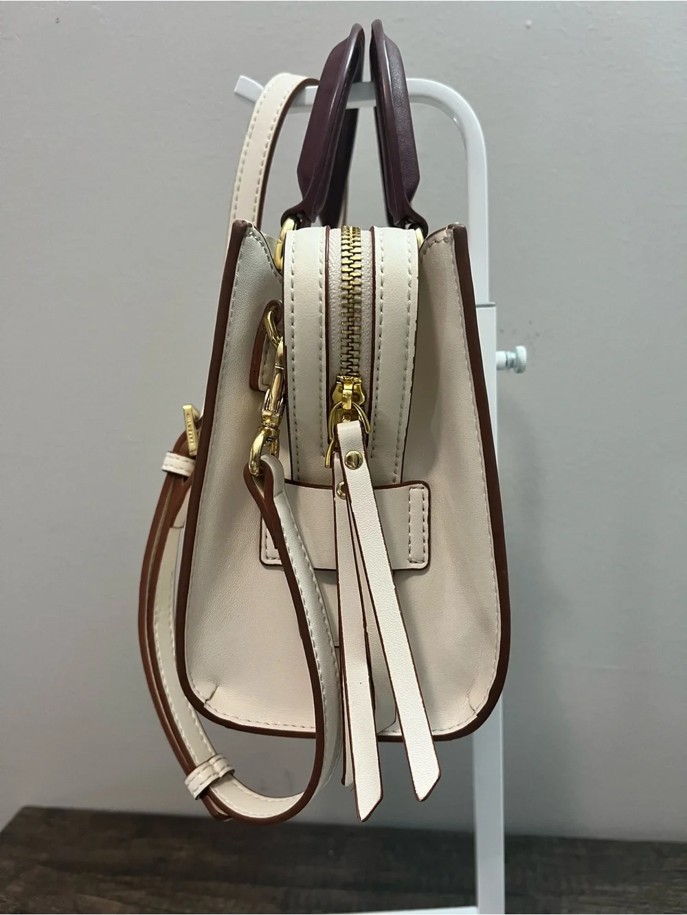 Cream Leather with contrasting plum handles and goldtone hardware crossbody.